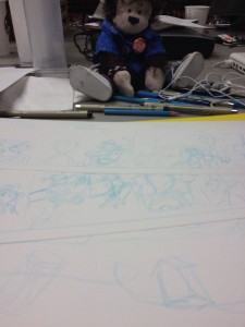 Cecil looks over the finished pencils for upcoming strips.