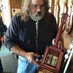 Richard shows us the innards of the electric cigar box uke he built.